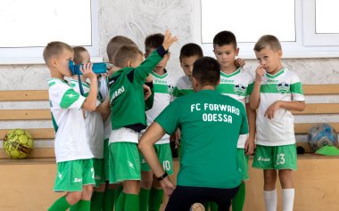 ODESSA, UKRAINE - 14 Ekim 2021: Küçük çocuklar 8-9 yaşlarında, Ukrayna Şampiyonası 'nda spor salonunda mini futbol oynuyorlar. Çocuk sporları sağlıklı yaşam tarzıdır. Erkek sporcular futsal yapıyor.