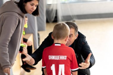 ODESSA, UKRAINE - 14 Ekim 2021: Küçük çocuklar 8-9 yaşlarında, Ukrayna Şampiyonası 'nda spor salonunda mini futbol oynuyorlar. Çocuk sporları sağlıklı yaşam tarzıdır. Erkek sporcular futsal yapıyor.