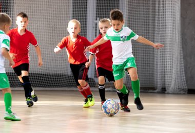 ODESSA, UKRAINE - 14 Ekim 2021: Küçük çocuklar 8-9 yaşlarında, Ukrayna Şampiyonası 'nda spor salonunda mini futbol oynuyorlar. Çocuk sporları sağlıklı yaşam tarzıdır. Erkek sporcular futsal yapıyor.