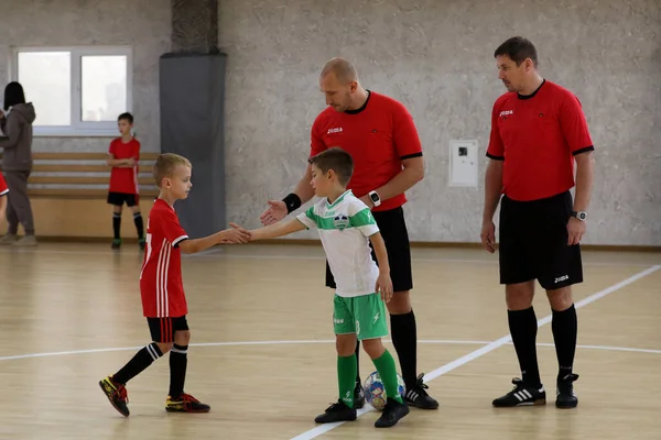 ODESSA, UKRAINE - 14 Ekim 2021: Küçük çocuklar 8-9 yaşlarında, Ukrayna Şampiyonası 'nda spor salonunda mini futbol oynuyorlar. Çocuk sporları sağlıklı yaşam tarzıdır. Erkek sporcular futsal yapıyor.