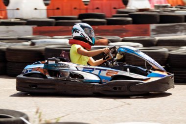 ODESSA, UKRAINE - 18 Haziran 2022: Karting. Devam et Kart. Otomobil pistinde araba yarışı sırasında kask takan genç pozitif kız yarışçı. Spor kulübünde aşırı otomobil sporu
