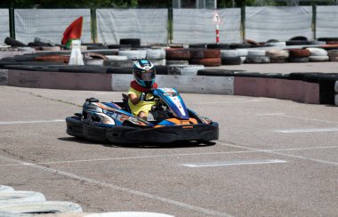 ODESSA, UKRAINE - 18 Haziran 2022: Karting. Devam et Kart. Otomobil pistinde araba yarışı sırasında kask takan genç pozitif kız yarışçı. Spor kulübünde aşırı otomobil sporu