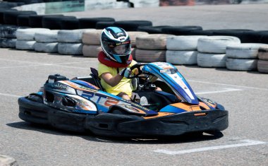 ODESSA, UKRAINE - 18 Haziran 2022: Karting. Devam et Kart. Otomobil pistinde araba yarışı sırasında kask takan genç pozitif kız yarışçı. Spor kulübünde aşırı otomobil sporu