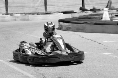 ODESSA, UKRAINE - 18 Haziran 2022: Karting. Devam et Kart. Otomobil pistinde araba yarışı sırasında kask takan genç pozitif kız yarışçı. Spor kulübünde aşırı otomobil sporu