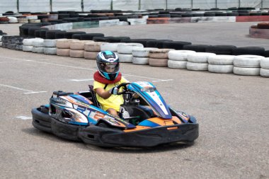 ODESSA, UKRAINE - 18 Haziran 2022: Karting. Devam et Kart. Otomobil pistinde araba yarışı sırasında kask takan genç pozitif kız yarışçı. Spor kulübünde aşırı otomobil sporu