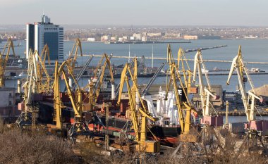 ODESSA, UKRAINE-NOVEMBER 27, 2021: Odessa commercial sea port in peacetime 4 months before start of war with Russia. Marine cranes, warehouses, tankers, cargo, containers and ships in  seaport harbor