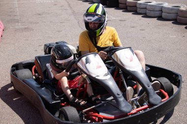 ODESSA, UKRAINE - August 7, 2022: Healthy lifestyle. Sport family. Family vacation at karting track. Children with parents go in for motorsports. Karting. Hobbies, sports education, leisure, lifestyle