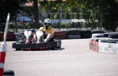 ODESSA, UKRAINE - August 7, 2022: Healthy lifestyle. Sport family. Family vacation at karting track. Children with parents go in for motorsports. Karting. Hobbies, sports education, leisure, lifestyle