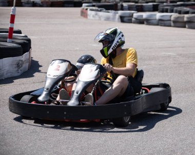 ODESSA, UKRAINE - August 7, 2022: Healthy lifestyle. Sport family. Family vacation at karting track. Children with parents go in for motorsports. Karting. Hobbies, sports education, leisure, lifestyle