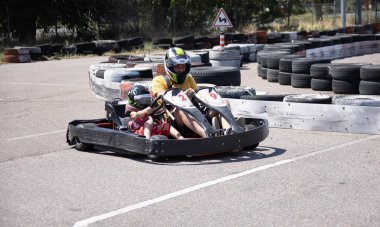 ODESSA, UKRAINE - August 7, 2022: Healthy lifestyle. Sport family. Family vacation at karting track. Children with parents go in for motorsports. Karting. Hobbies, sports education, leisure, lifestyle