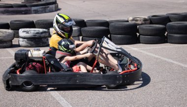 ODESSA, UKRAINE - August 7, 2022: Healthy lifestyle. Sport family. Family vacation at karting track. Children with parents go in for motorsports. Karting. Hobbies, sports education, leisure, lifestyle