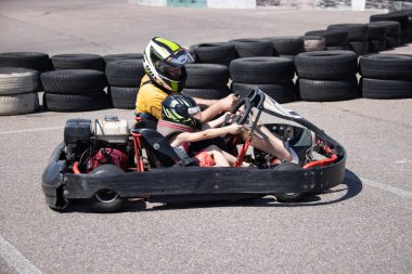 ODESSA, UKRAINE - August 7, 2022: Healthy lifestyle. Sport family. Family vacation at karting track. Children with parents go in for motorsports. Karting. Hobbies, sports education, leisure, lifestyle