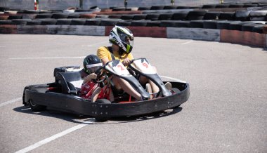 ODESSA, UKRAINE - August 7, 2022: Healthy lifestyle. Sport family. Family vacation at karting track. Children with parents go in for motorsports. Karting. Hobbies, sports education, leisure, lifestyle