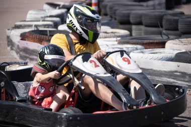 ODESSA, UKRAINE - August 7, 2022: Healthy lifestyle. Sport family. Family vacation at karting track. Children with parents go in for motorsports. Karting. Hobbies, sports education, leisure, lifestyle