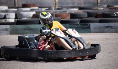 ODESSA, UKRAINE - August 7, 2022: Healthy lifestyle. Sport family. Family vacation at karting track. Children with parents go in for motorsports. Karting. Hobbies, sports education, leisure, lifestyle