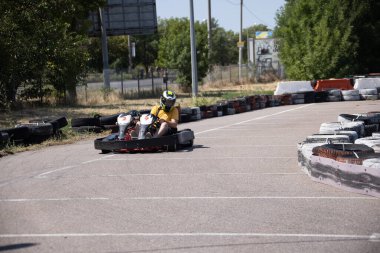 ODESSA, UKRAINE - August 7, 2022: Healthy lifestyle. Sport family. Family vacation at karting track. Children with parents go in for motorsports. Karting. Hobbies, sports education, leisure, lifestyle
