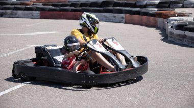 ODESSA, UKRAINE - August 7, 2022: Healthy lifestyle. Sport family. Family vacation at karting track. Children with parents go in for motorsports. Karting. Hobbies, sports education, leisure, lifestyle
