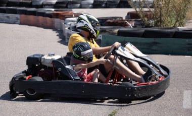 ODESSA, UKRAINE - August 7, 2022: Healthy lifestyle. Sport family. Family vacation at karting track. Children with parents go in for motorsports. Karting. Hobbies, sports education, leisure, lifestyle