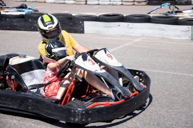 ODESSA, UKRAINE - August 7, 2022: Healthy lifestyle. Sport family. Family vacation at karting track. Children with parents go in for motorsports. Karting. Hobbies, sports education, leisure, lifestyle