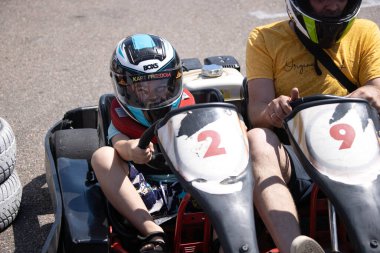 ODESSA, UKRAINE - August 7, 2022: Healthy lifestyle. Sport family. Family vacation at karting track. Children with parents go in for motorsports. Karting. Hobbies, sports education, leisure, lifestyle