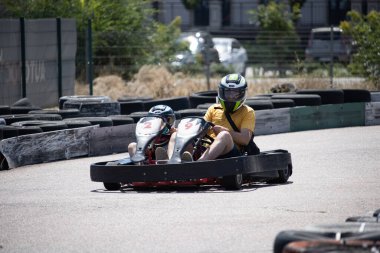 ODESSA, UKRAINE - August 7, 2022: Healthy lifestyle. Sport family. Family vacation at karting track. Children with parents go in for motorsports. Karting. Hobbies, sports education, leisure, lifestyle