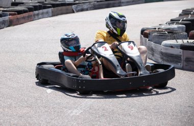 ODESSA, UKRAINE - August 7, 2022: Healthy lifestyle. Sport family. Family vacation at karting track. Children with parents go in for motorsports. Karting. Hobbies, sports education, leisure, lifestyle