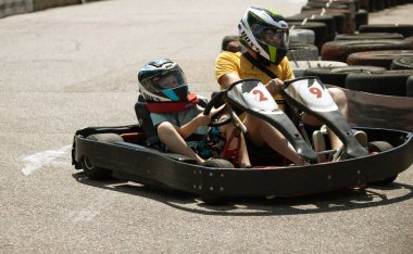ODESSA, UKRAINE - August 7, 2022: Healthy lifestyle. Sport family. Family vacation at karting track. Children with parents go in for motorsports. Karting. Hobbies, sports education, leisure, lifestyle