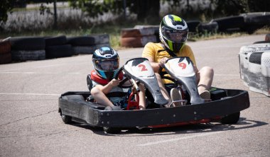 ODESSA, UKRAINE - August 7, 2022: Healthy lifestyle. Sport family. Family vacation at karting track. Children with parents go in for motorsports. Karting. Hobbies, sports education, leisure, lifestyle