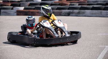 ODESSA, UKRAINE - August 7, 2022: Healthy lifestyle. Sport family. Family vacation at karting track. Children with parents go in for motorsports. Karting. Hobbies, sports education, leisure, lifestyle
