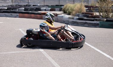 ODESSA, UKRAINE - August 7, 2022: Healthy lifestyle. Sport family. Family vacation at karting track. Children with parents go in for motorsports. Karting. Hobbies, sports education, leisure, lifestyle