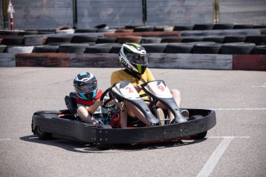 ODESSA, UKRAINE - August 7, 2022: Healthy lifestyle. Sport family. Family vacation at karting track. Children with parents go in for motorsports. Karting. Hobbies, sports education, leisure, lifestyle