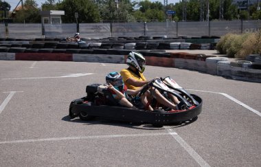 ODESSA, UKRAINE - August 7, 2022: Healthy lifestyle. Sport family. Family vacation at karting track. Children with parents go in for motorsports. Karting. Hobbies, sports education, leisure, lifestyle