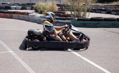 ODESSA, UKRAINE - August 7, 2022: Healthy lifestyle. Sport family. Family vacation at karting track. Children with parents go in for motorsports. Karting. Hobbies, sports education, leisure, lifestyle