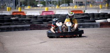 ODESSA, UKRAINE - August 7, 2022: Healthy lifestyle. Sport family. Family vacation at karting track. Children with parents go in for motorsports. Karting. Hobbies, sports education, leisure, lifestyle