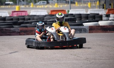 ODESSA, UKRAINE - August 7, 2022: Healthy lifestyle. Sport family. Family vacation at karting track. Children with parents go in for motorsports. Karting. Hobbies, sports education, leisure, lifestyle