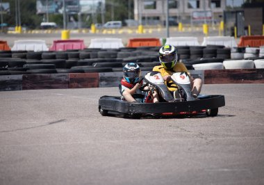 ODESSA, UKRAINE - August 7, 2022: Healthy lifestyle. Sport family. Family vacation at karting track. Children with parents go in for motorsports. Karting. Hobbies, sports education, leisure, lifestyle