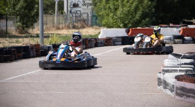 ODESSA, UKRAINE - August 7, 2022: Healthy lifestyle. Sport family. Family vacation at karting track. Children with parents go in for motorsports. Karting. Hobbies, sports education, leisure, lifestyle