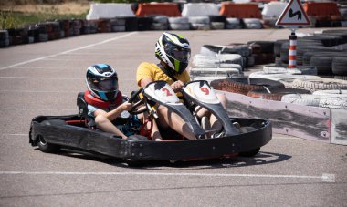 ODESSA, UKRAINE - August 7, 2022: Healthy lifestyle. Sport family. Family vacation at karting track. Children with parents go in for motorsports. Karting. Hobbies, sports education, leisure, lifestyle