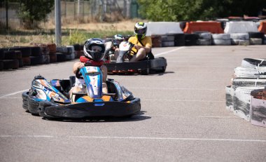 ODESSA, UKRAINE - August 7, 2022: Healthy lifestyle. Sport family. Family vacation at karting track. Children with parents go in for motorsports. Karting. Hobbies, sports education, leisure, lifestyle