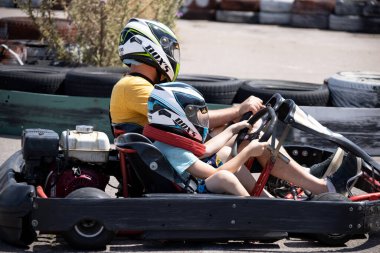 ODESSA, UKRAINE - August 7, 2022: Healthy lifestyle. Sport family. Family vacation at karting track. Children with parents go in for motorsports. Karting. Hobbies, sports education, leisure, lifestyle
