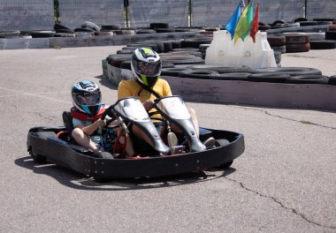 ODESSA, UKRAINE - August 7, 2022: Healthy lifestyle. Sport family. Family vacation at karting track. Children with parents go in for motorsports. Karting. Hobbies, sports education, leisure, lifestyle