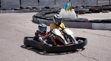 ODESSA, UKRAINE - August 7, 2022: Healthy lifestyle. Sport family. Family vacation at karting track. Children with parents go in for motorsports. Karting. Hobbies, sports education, leisure, lifestyle