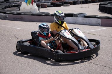 ODESSA, UKRAINE - August 7, 2022: Healthy lifestyle. Sport family. Family vacation at karting track. Children with parents go in for motorsports. Karting. Hobbies, sports education, leisure, lifestyle