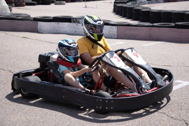 ODESSA, UKRAINE - August 7, 2022: Healthy lifestyle. Sport family. Family vacation at karting track. Children with parents go in for motorsports. Karting. Hobbies, sports education, leisure, lifestyle