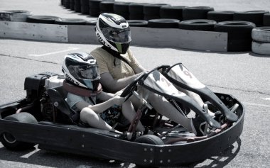 ODESSA, UKRAINE - August 7, 2022: Healthy lifestyle. Sport family. Family vacation at karting track. Children with parents go in for motorsports. Karting. Hobbies, sports education, leisure, lifestyle