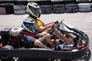 ODESSA, UKRAINE - August 7, 2022: Healthy lifestyle. Sport family. Family vacation at karting track. Children with parents go in for motorsports. Karting. Hobbies, sports education, leisure, lifestyle