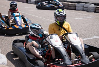 ODESSA, UKRAINE - August 7, 2022: Healthy lifestyle. Sport family. Family vacation at karting track. Children with parents go in for motorsports. Karting. Hobbies, sports education, leisure, lifestyle