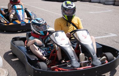 ODESSA, UKRAINE - August 7, 2022: Healthy lifestyle. Sport family. Family vacation at karting track. Children with parents go in for motorsports. Karting. Hobbies, sports education, leisure, lifestyle