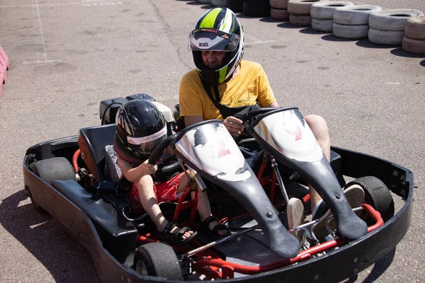 ODESSA, UKRAINE - August 7, 2022: Healthy lifestyle. Sport family. Family vacation at karting track. Children with parents go in for motorsports. Karting. Hobbies, sports education, leisure, lifestyle