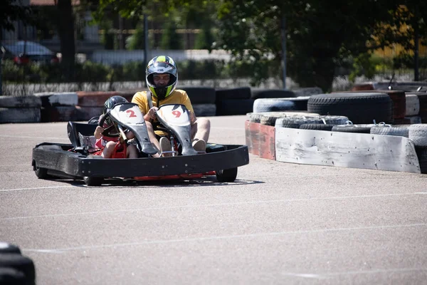 ODESSA, UKRAINE - August 7, 2022: Healthy lifestyle. Sport family. Family vacation at karting track. Children with parents go in for motorsports. Karting. Hobbies, sports education, leisure, lifestyle